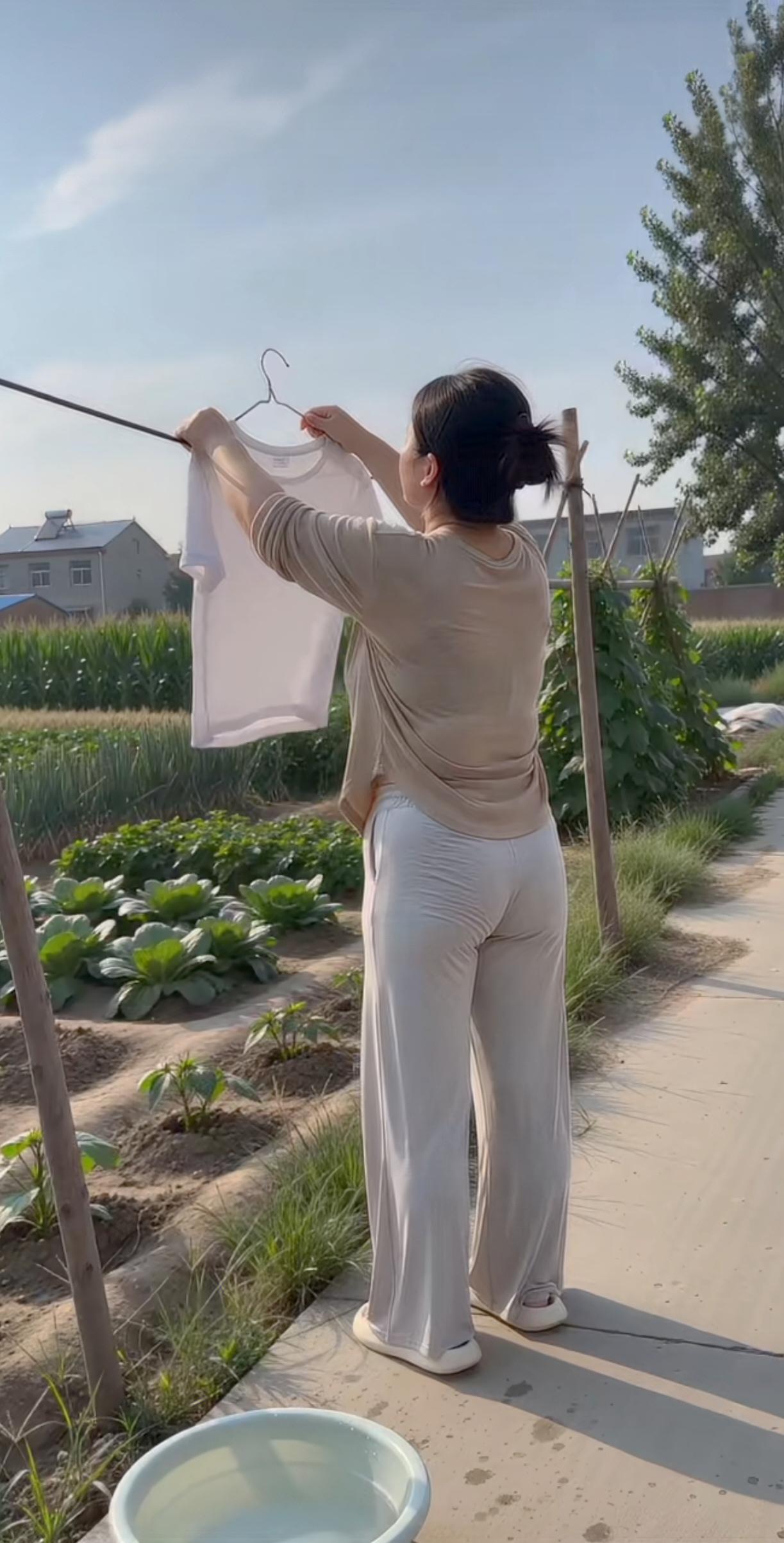 勤快的少妇在晒衣服。