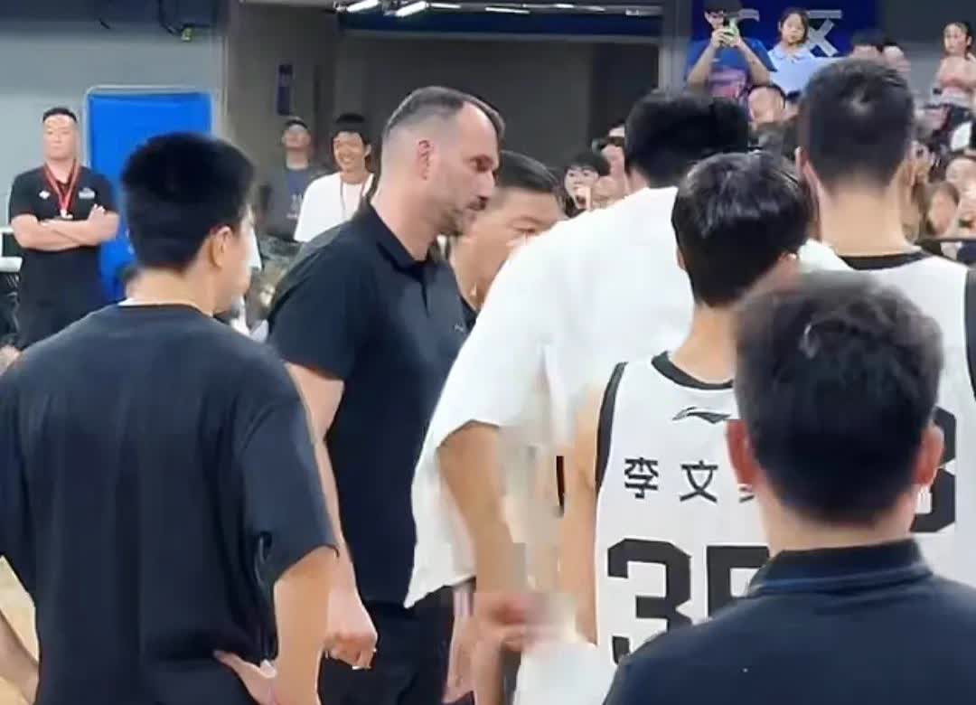 广东新来的助教拉多维奇首次随队出征粤澳明星赛，暂停时他跟球员一起，看着杜锋画战术
