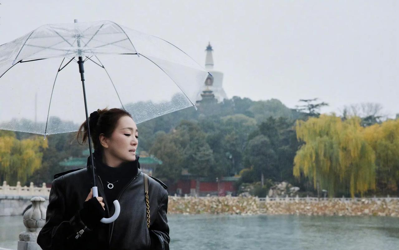 巩俐北海公园雨中漫步，59岁状态引热议！北京冬雨中的北海公园，迎来了一位特别的游