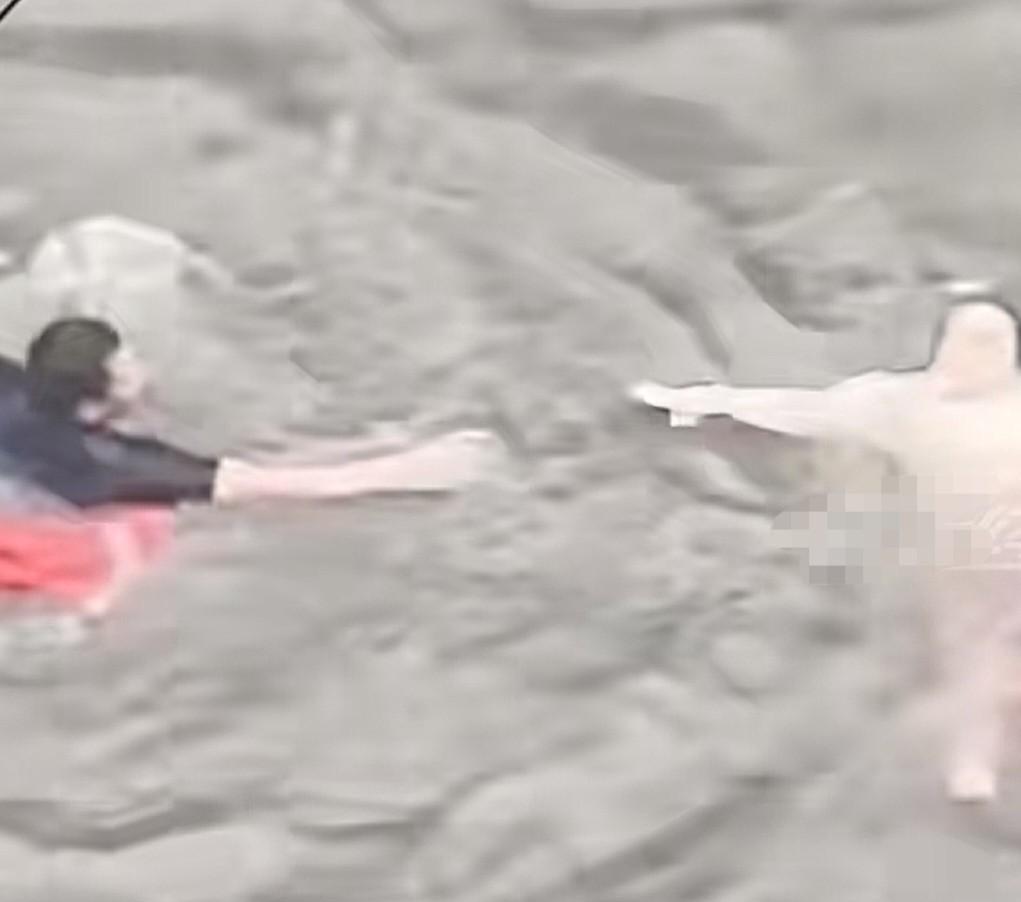 广东暴雨，一女子不小心掉进洪水中，岸上的人慌乱喊“救命”，然而，奇怪的是，女子却
