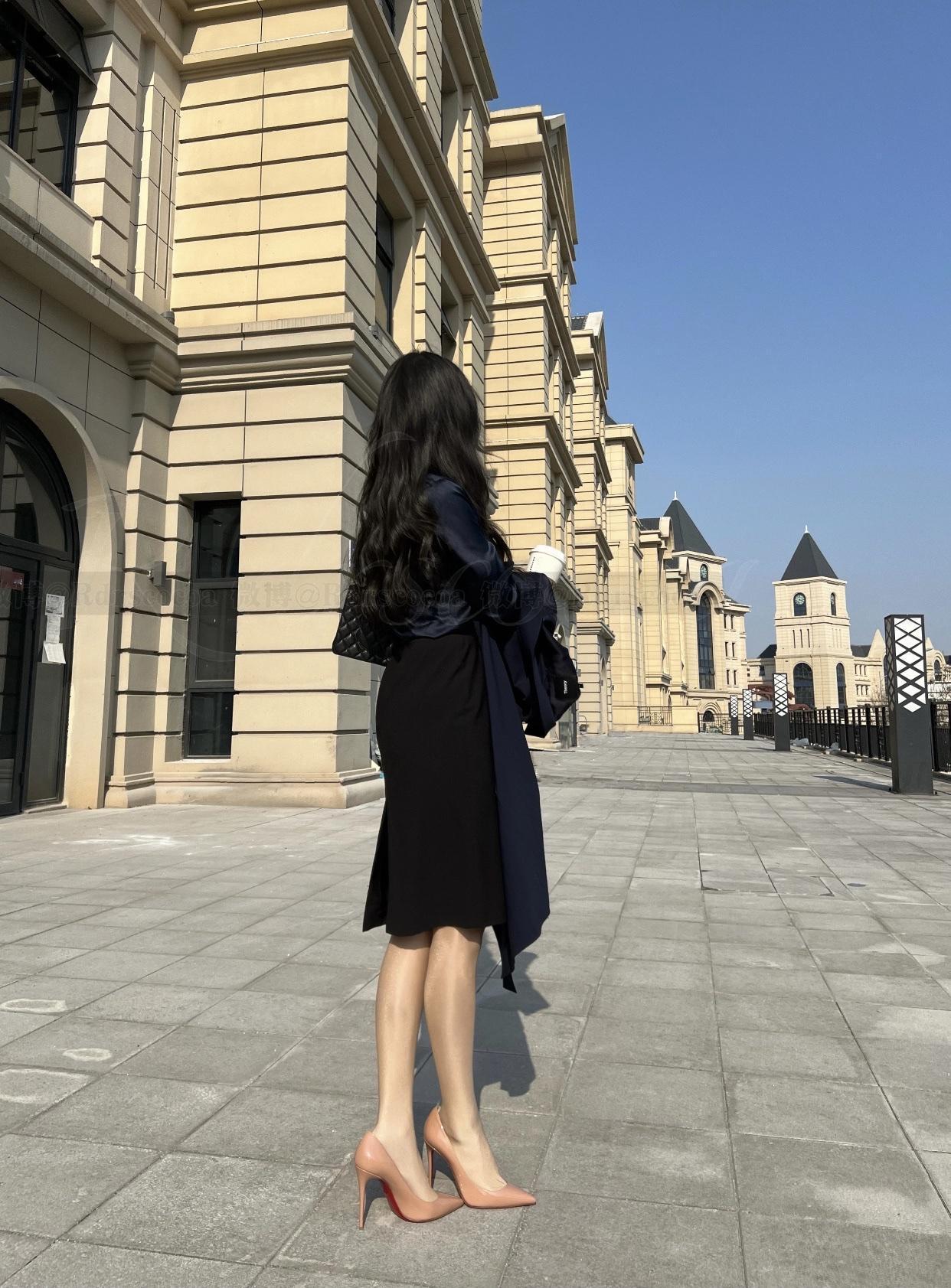 优雅漫步在欧式建筑旁，黑色裙装与红高跟鞋相得益彰。