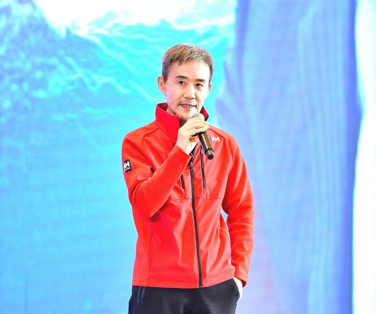 有地产教父之称的王石亮相三亚，参加中国企业家大会，王石在台上演讲，一红色立领休闲