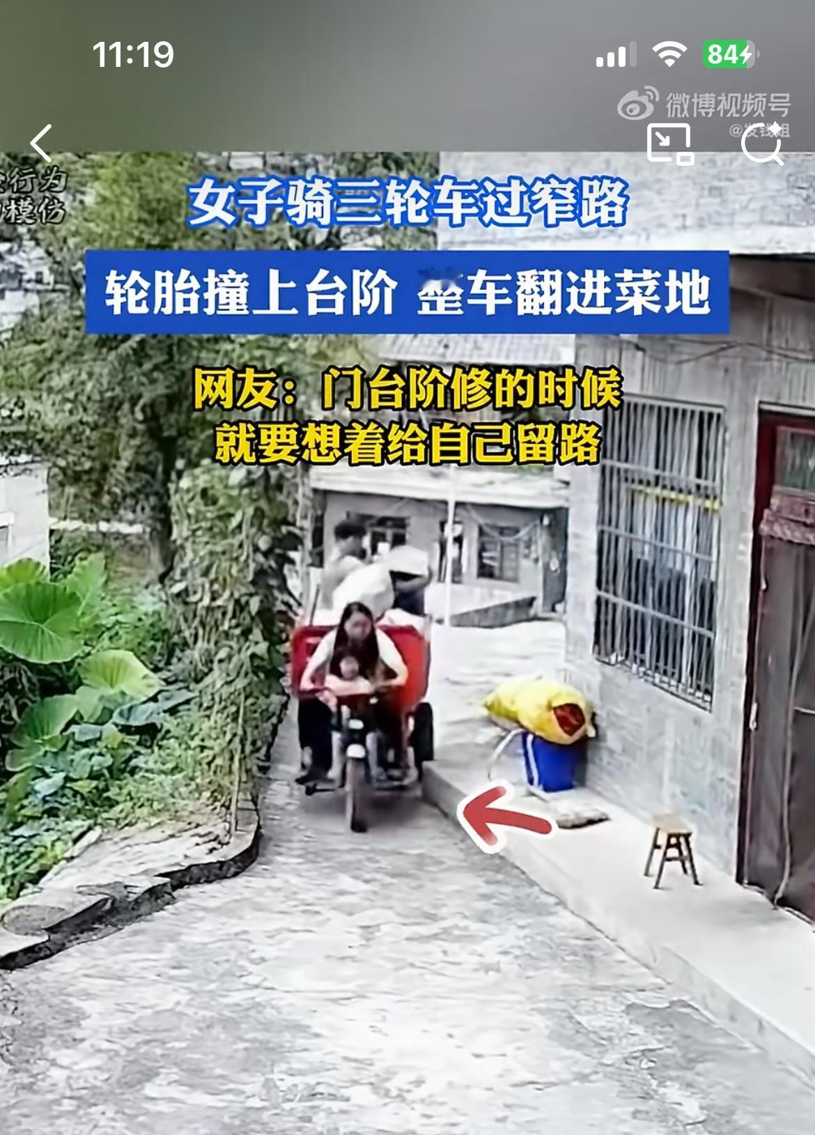 女子带着一家三口骑三轮车，碰到邻居家的廊檐，三轮车侧翻掉到沟坎下面的菜地里，两个