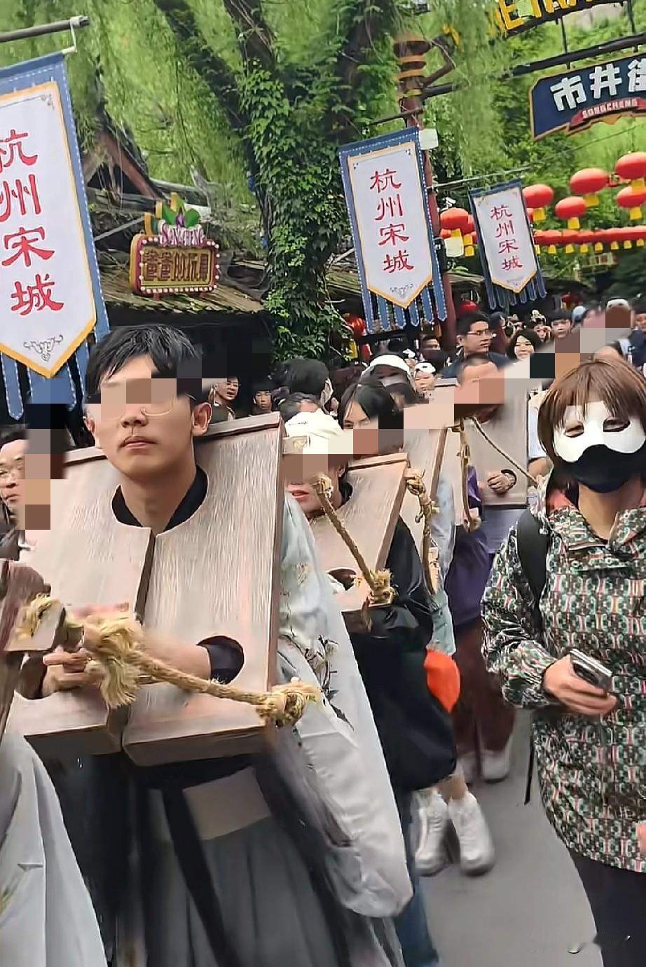 游客体验当囚犯游街？5月4日，杭州宋城景区内，一群年轻游客一字排开，正在体验