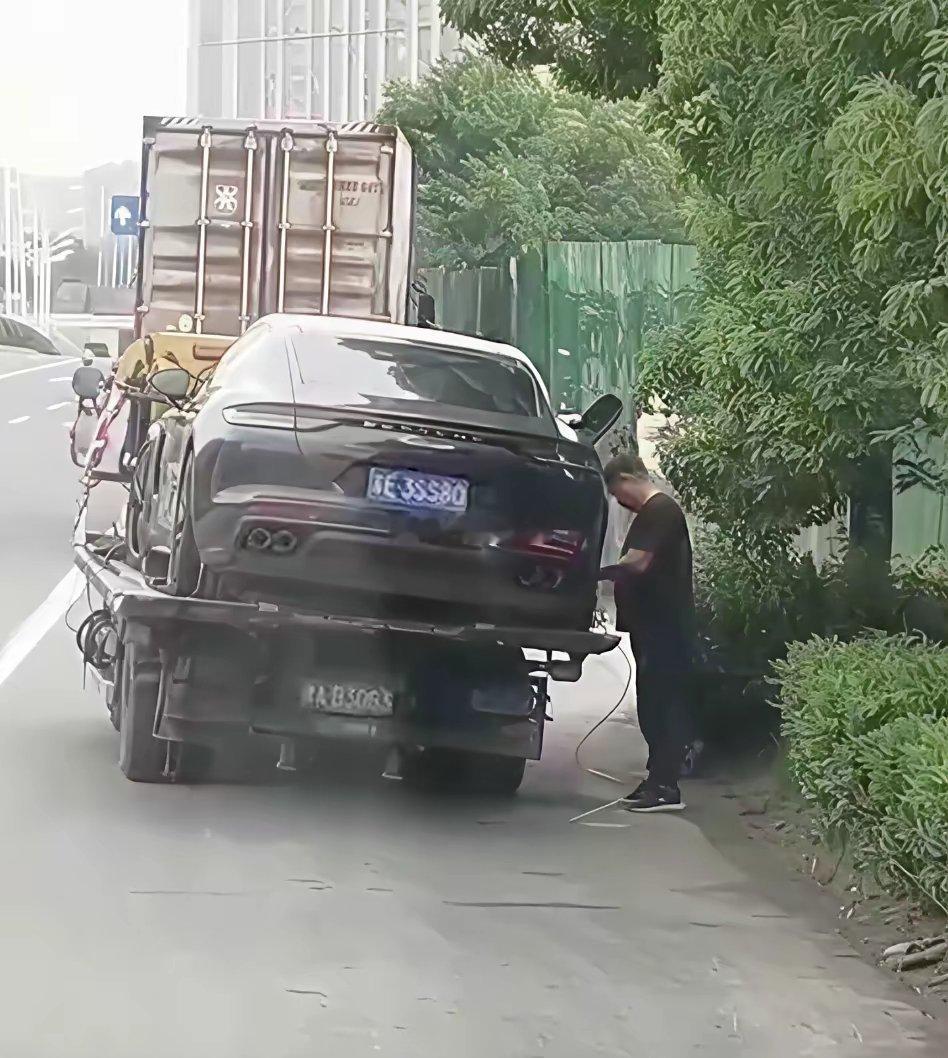 拖车人员在路边对事故保时捷公然抽油装满三桶，全程毫无遮掩