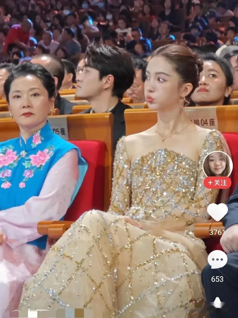 图片里何赛飞老师旁边的这个女人，有认识吗？她嘟起嘴巴，到底是在扮萌，还是在故意