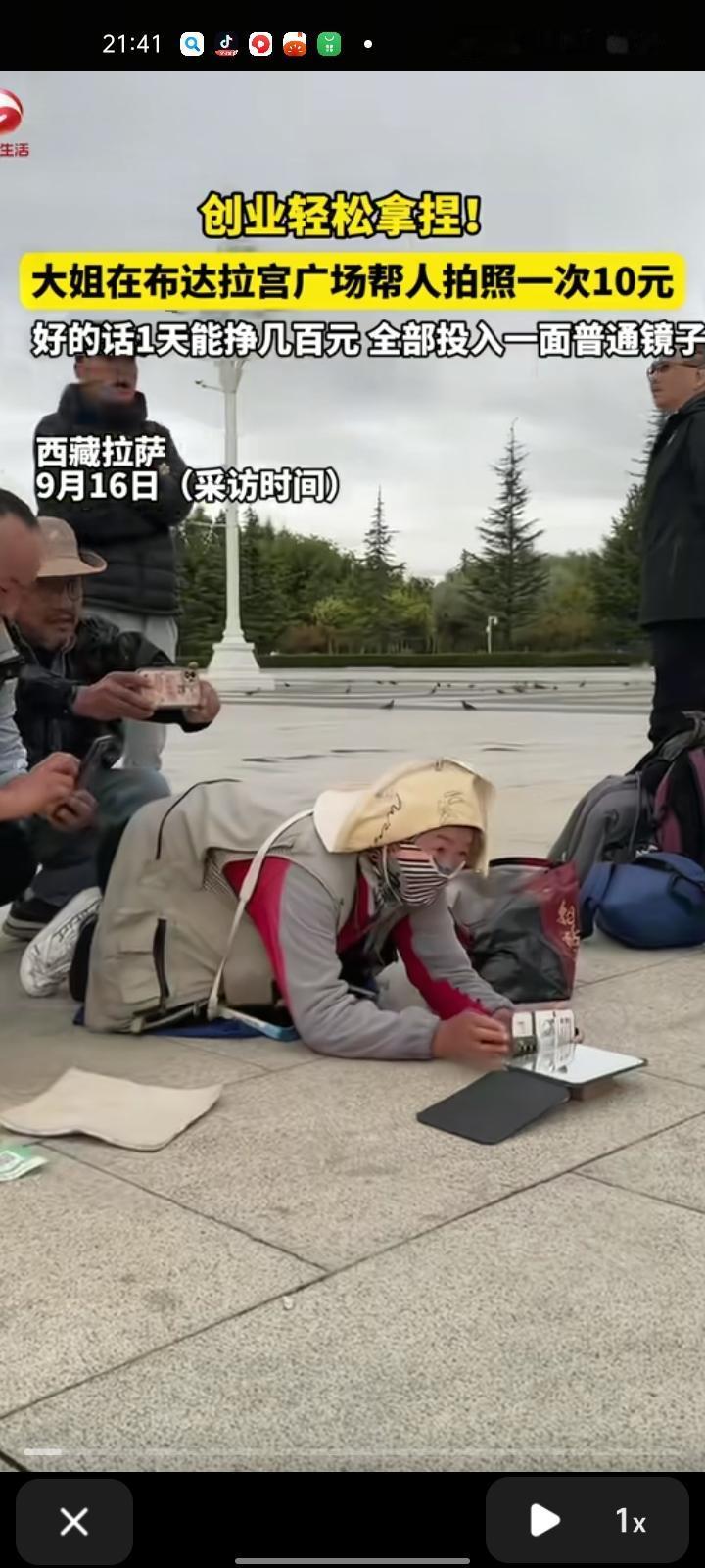 “真有做生意头脑！”西藏拉萨，一男子闲逛时，突然看到有位大姐趴在地上，帮旅客拍照