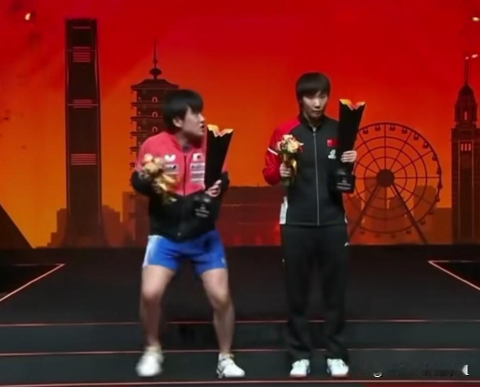 张本智和夺冠后与王曼昱合影时洋相百出，怪不得有人说他心中有鬼。看他一手掂着奖