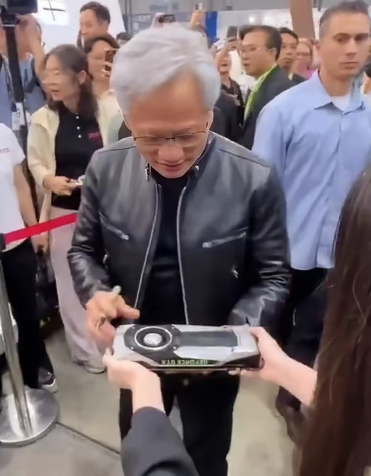 围观的粉丝拿出GeForceGTX1080要签名，黄仁勋盯着显卡看了几秒，然