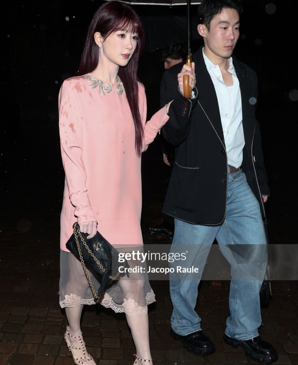 杨紫参加华伦大秀恰逢罗马雷雨天出场时，粉色连衣裙肩膀都是湿的！给杨紫撑伞的是