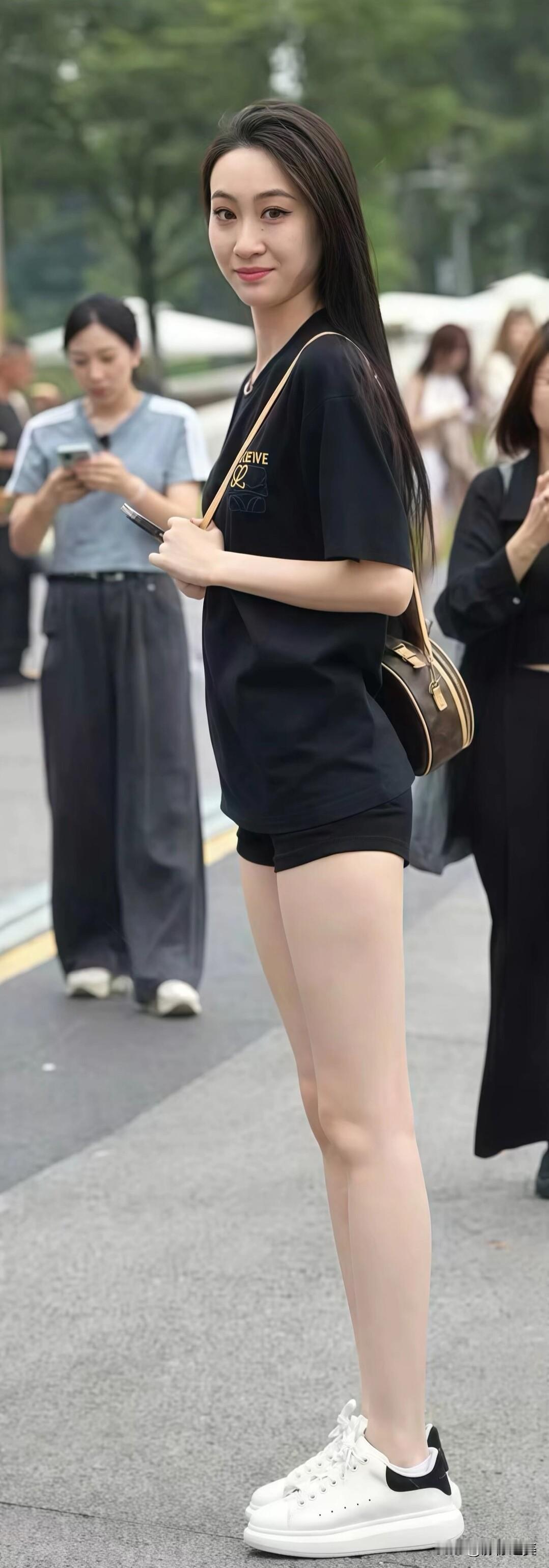 一身简约的黑色穿搭，简单的T恤短裤配上小白鞋，清爽又显气质，街头氛围感直接拉满。