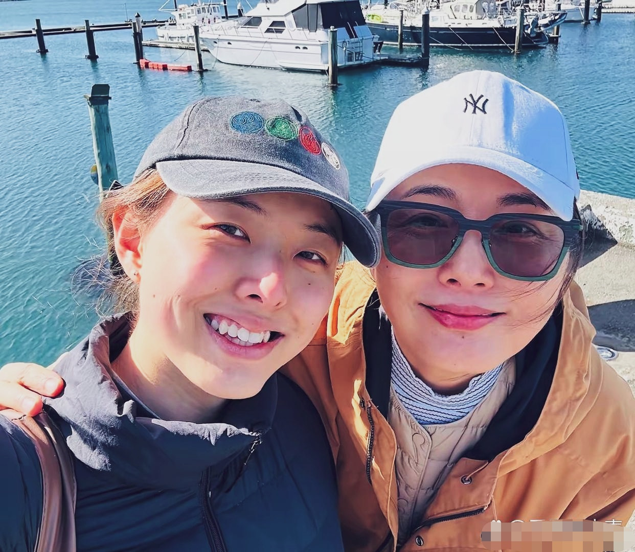 演员张延和女儿张耕梦，海边出游合照。一顶棒球帽，休闲穿搭，母女二人依偎在一起，面对镜头笑容恬淡。女儿