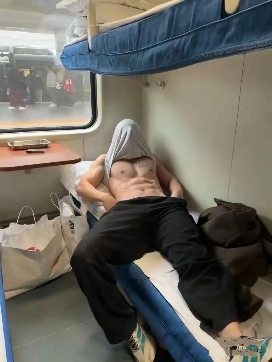 在火车上瞧见的，有个帅哥用背心蒙住头，双手插兜，好似在构建属于自己的一方小天地。