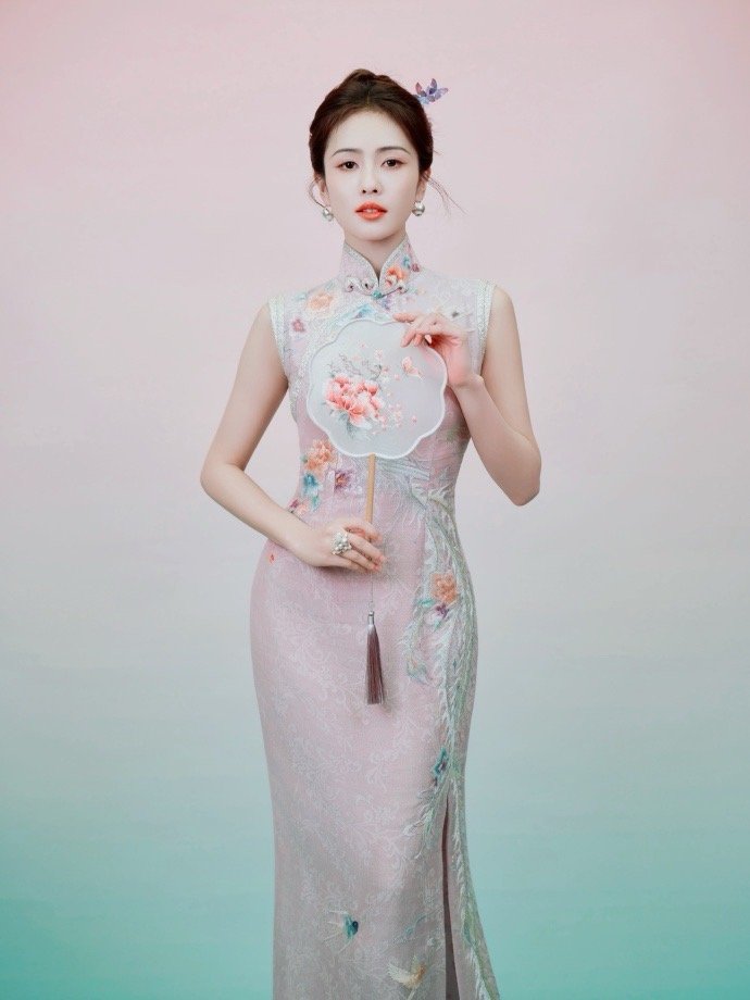 白鹿身着国风旗袍，宛如水墨画中走出的仙子。绯红旗袍上绣着繁复的金线，衬得她肌肤