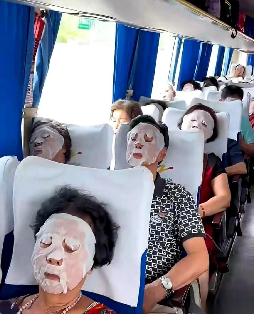 一辆老年团的大巴车，正开在路上。导游笑着，从前面走到后面，给每人发了一片东西。