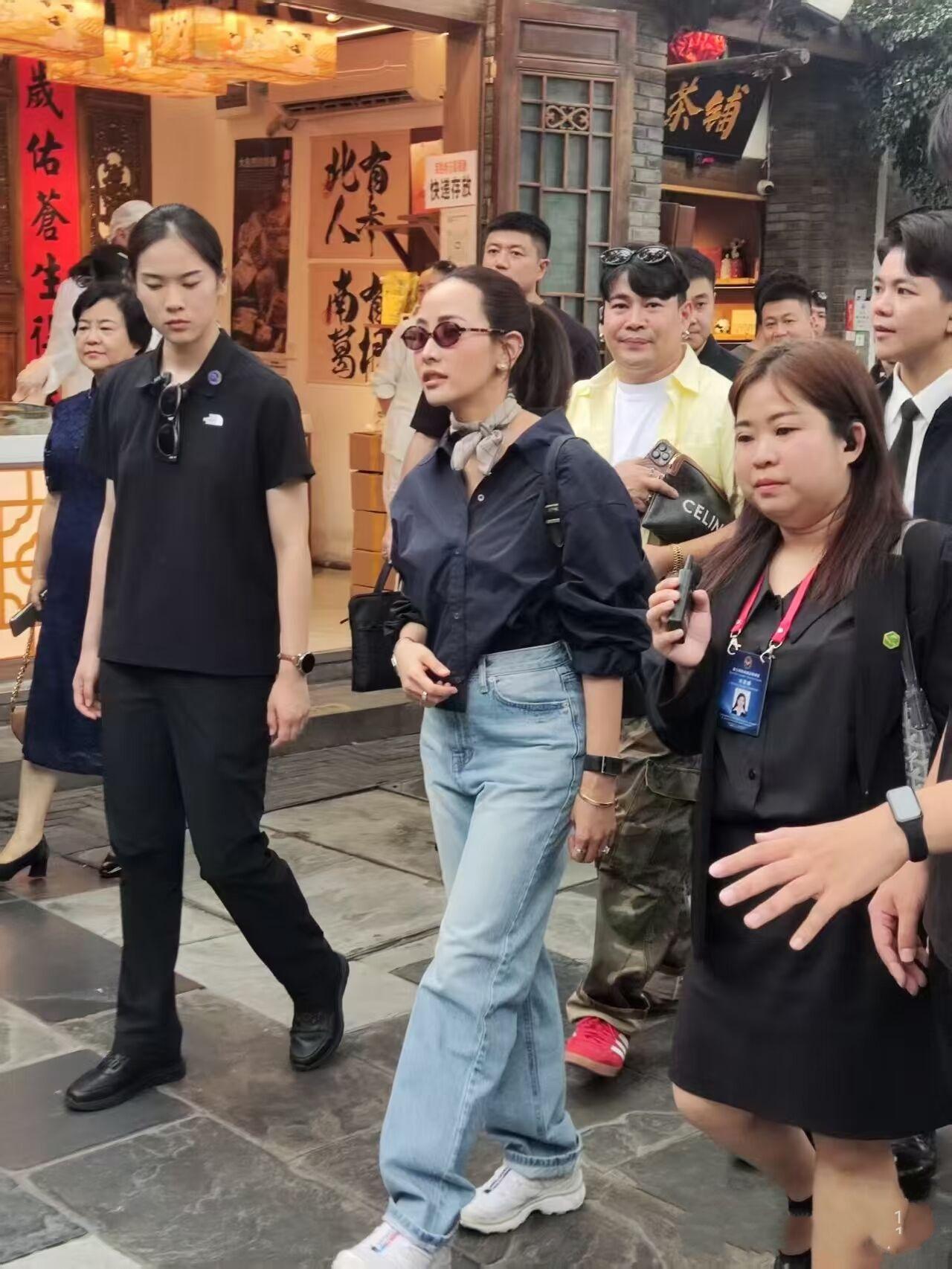 7月18日泰国总理夫人抵达成都后逛街被网友偶遇，穿着藏蓝色衬衫与浅蓝色牛仔裤，一