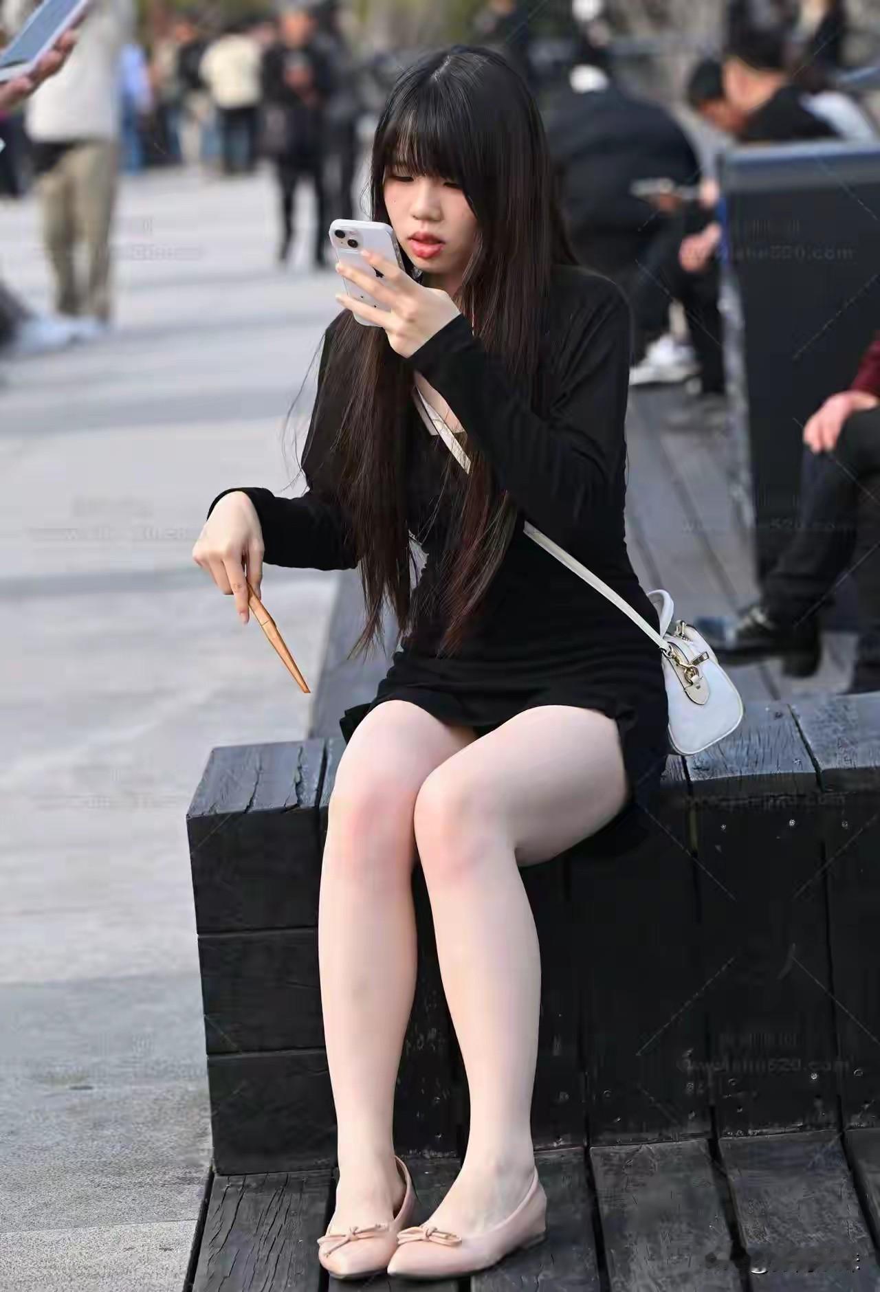 黑裙少女，手机相伴，悠然自得。