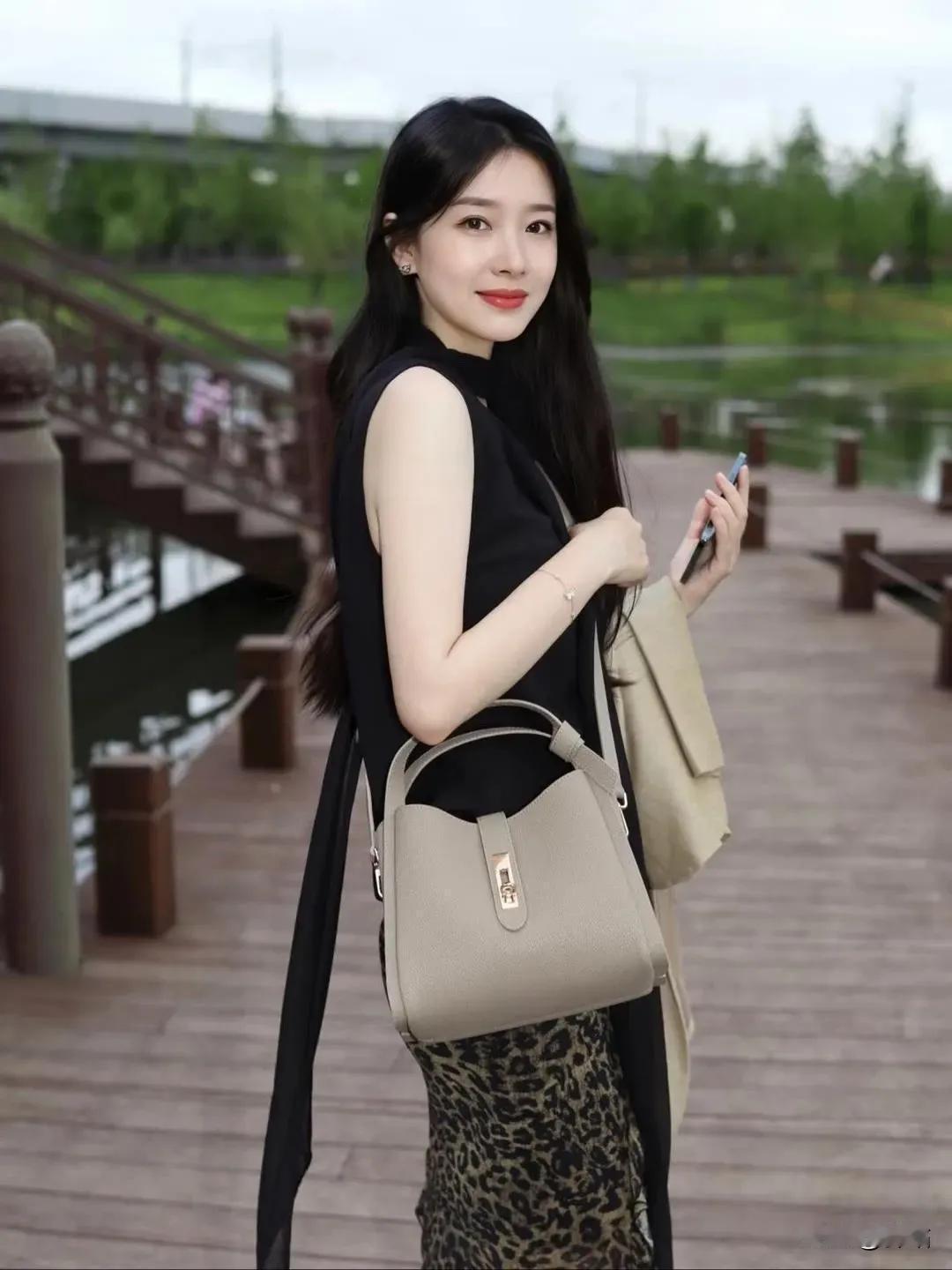 美图欣赏，看图写诗《时尚丽人》栈道晴光下，佳人倚岸旁。黑衫显雅致，豹裙韵