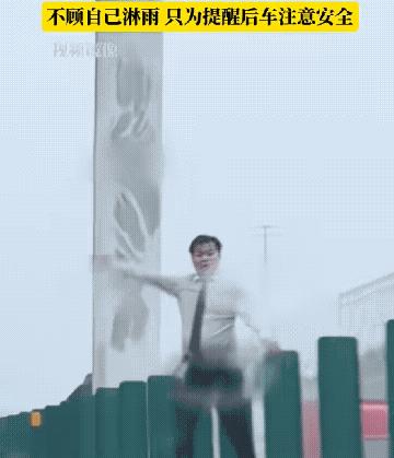 这位大哥人太好了！大哥不顾自己淋雨，爬到护栏上向司机们用力挥手，只为提醒后车注意