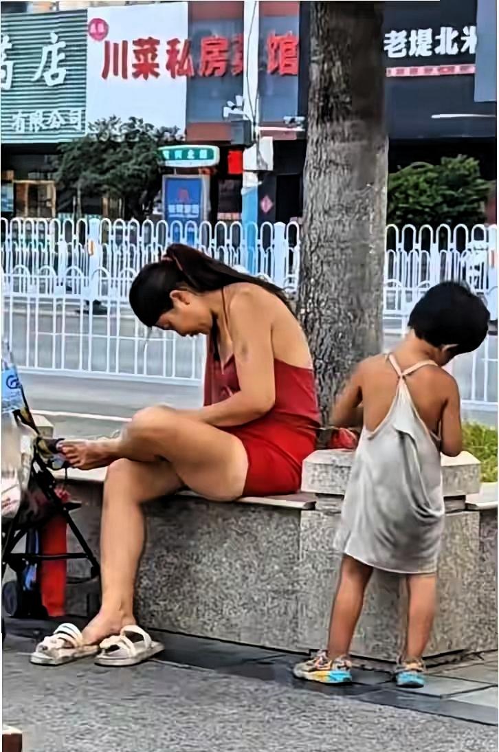 徐州街头出现一对特殊的流浪母女，母亲穿红色连衣裙打扮时尚，路人拍下视频后，大家纷
