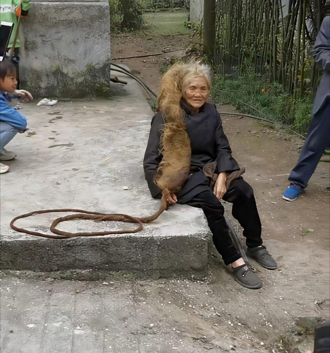 巷口老槐树下，暖阳筛下斑驳光影，我撞见了那位传闻中128岁的老奶奶。她佝偻着身子