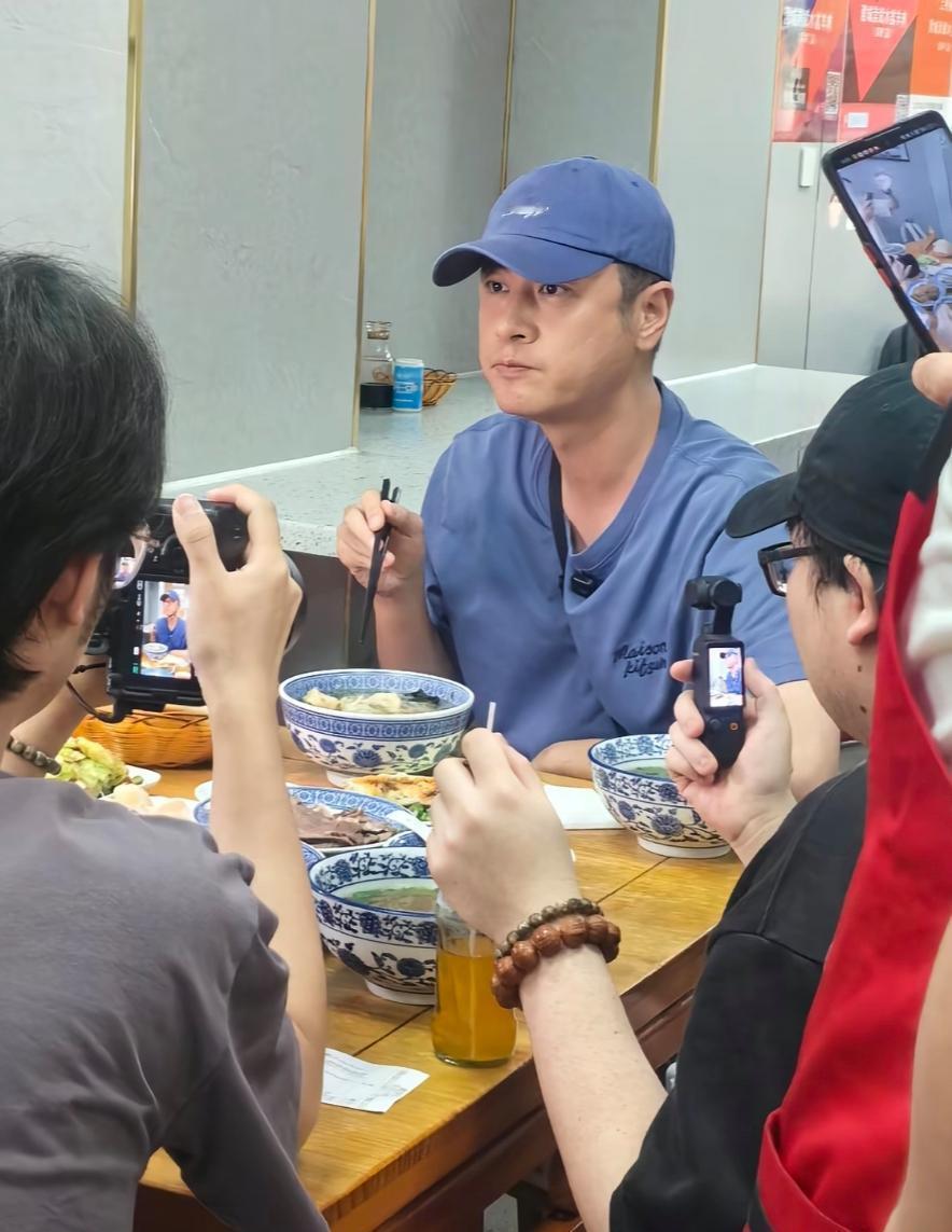 任重一身浅蓝色套装现身西安一家小餐馆品尝当地美食—羊肉泡馍。他和几位前来吃饭的普