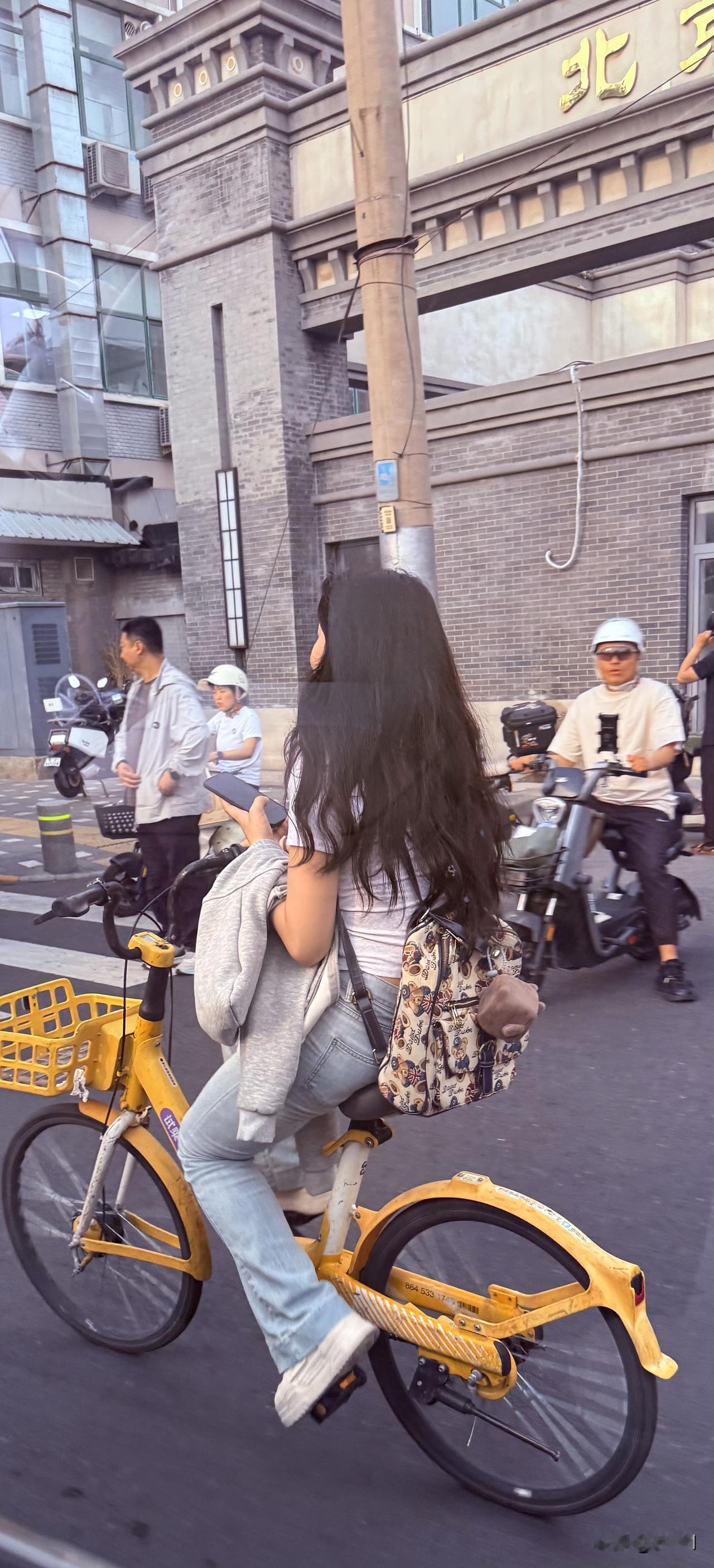北京街头随手拍北京街头发现很多这样骑行的女孩很潇洒，背着双肩背，一个手扶着车把，