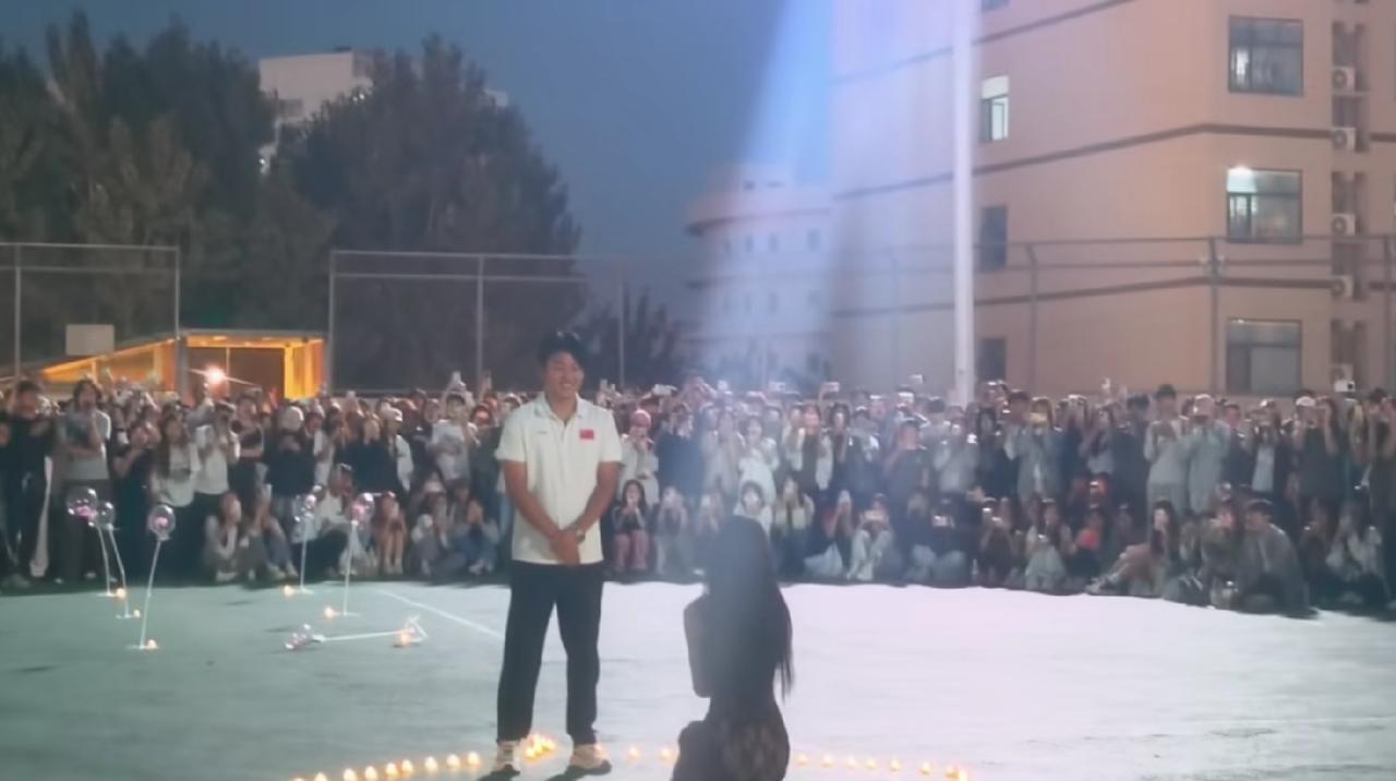 河北师院的操场上这波求婚直接把青春氛围感拉满了。女生提前摆好爱心蜡烛，穿了条特