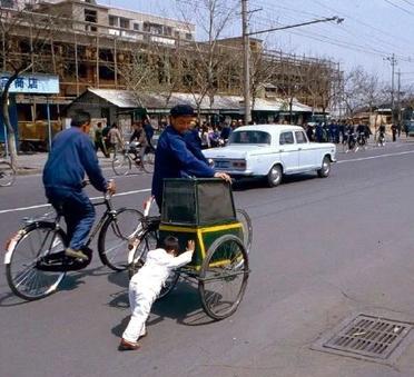 1984年，北京街头出现的一幕。爷爷骑在车上，小孙子下车后推车。这辆自行车也是爷