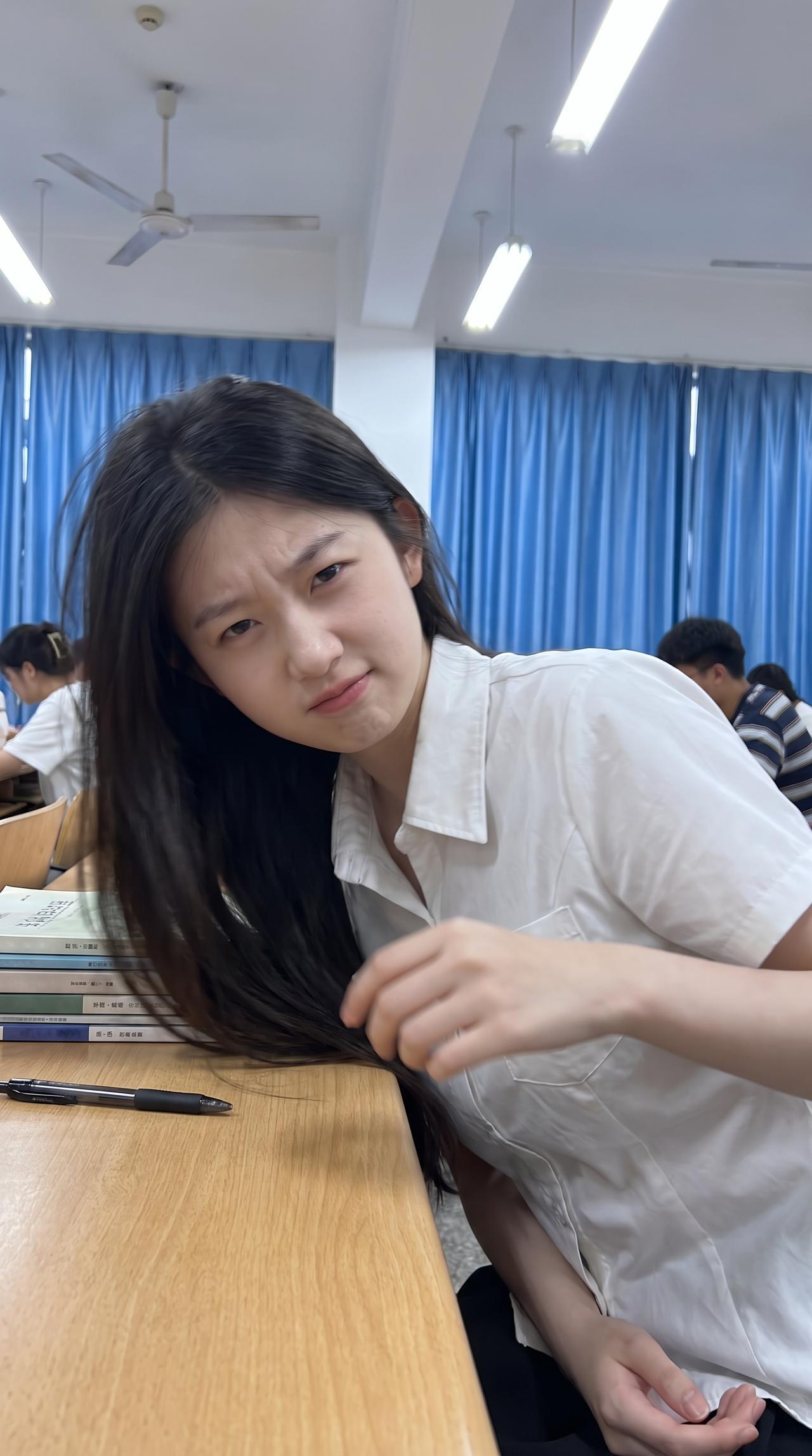 大一在教室自拍，坐得笔直，表情认真，课本翻开第一页，笔摆得整整齐齐。拍了十张才选