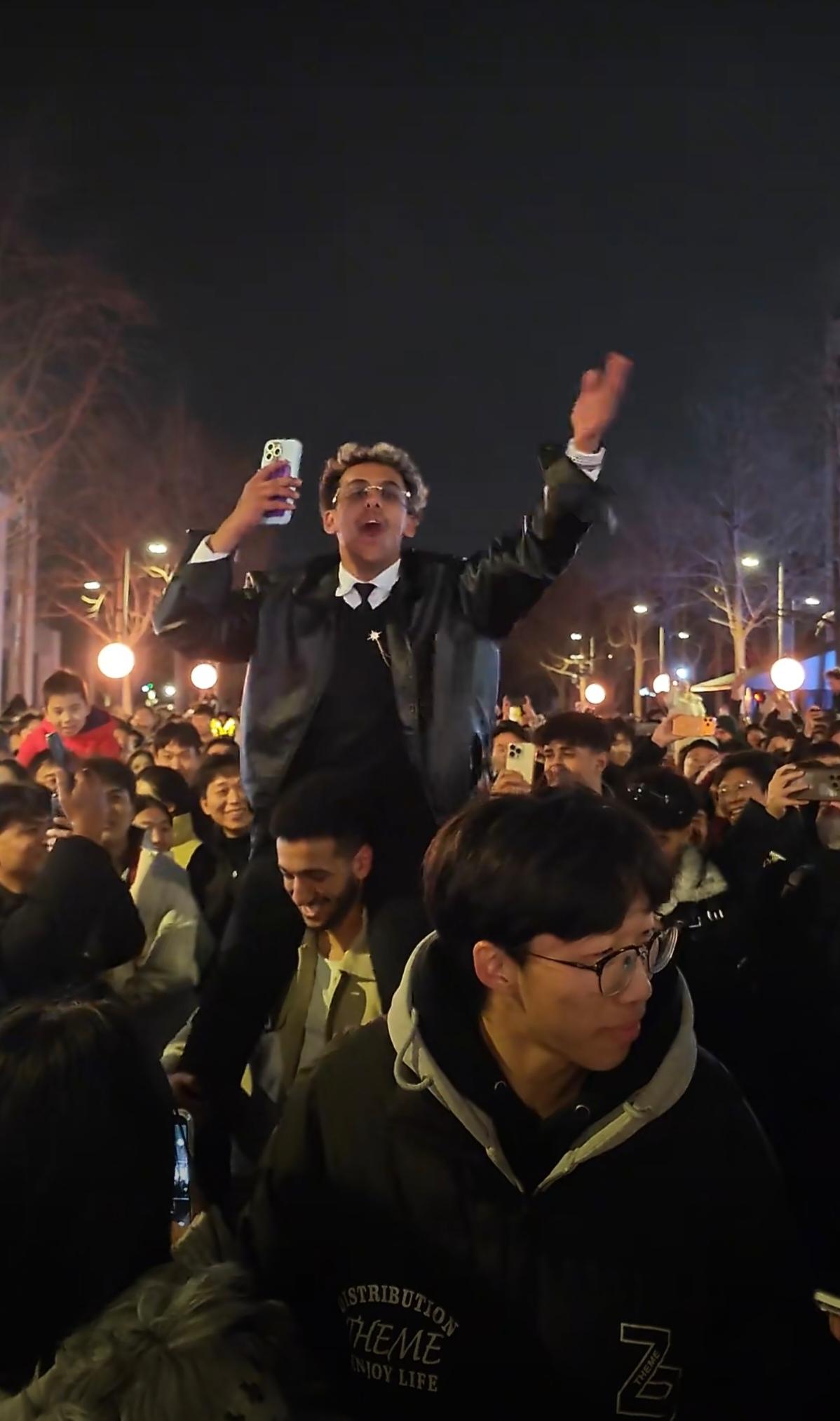 在中国某地的新年活动中，在密集人群中一个印度阿三骑在人肩上，拍视频用中文大喊“印