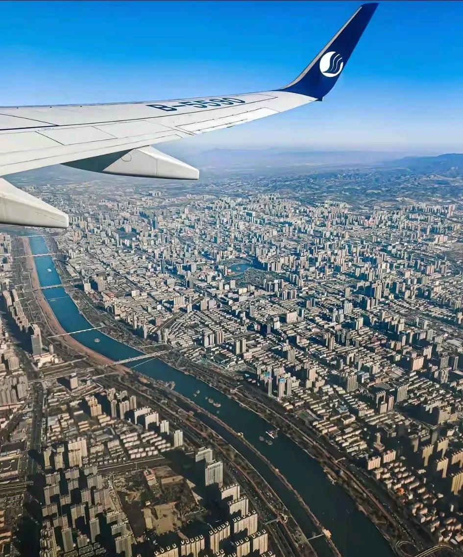 前几日从新疆去北京出差，飞机飞过北方某城市上空，市中心有条河流过，不算很宽，河上