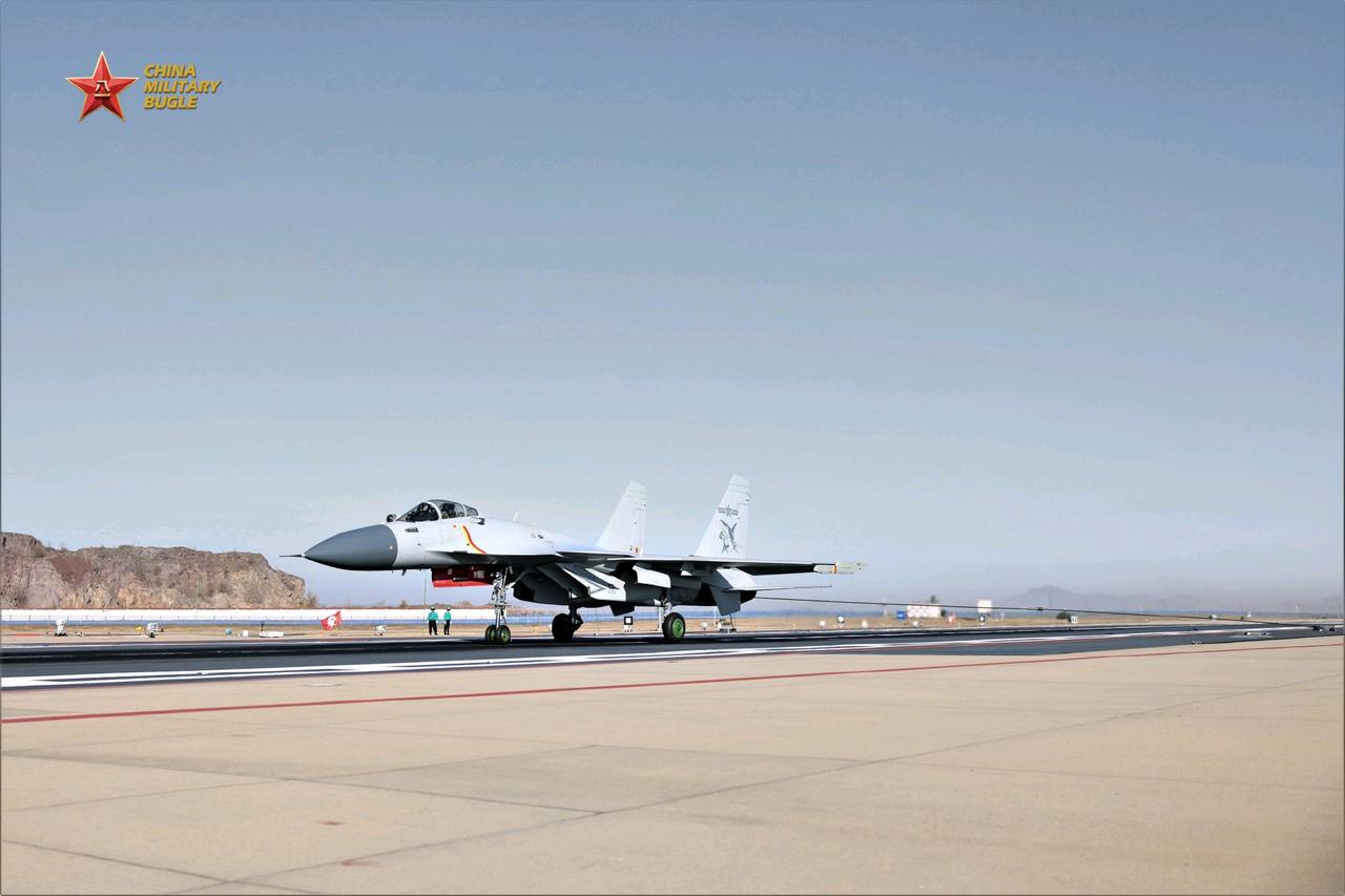 海军航空大学某舰载机训练基地正在进行舰载机着舰训练，飞机、地勤人员和航母上保持一