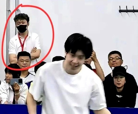 这张照片最令人动容的，不是快乐挥拍的王楚钦，也不是认真观看的观众，而是站在后面戴