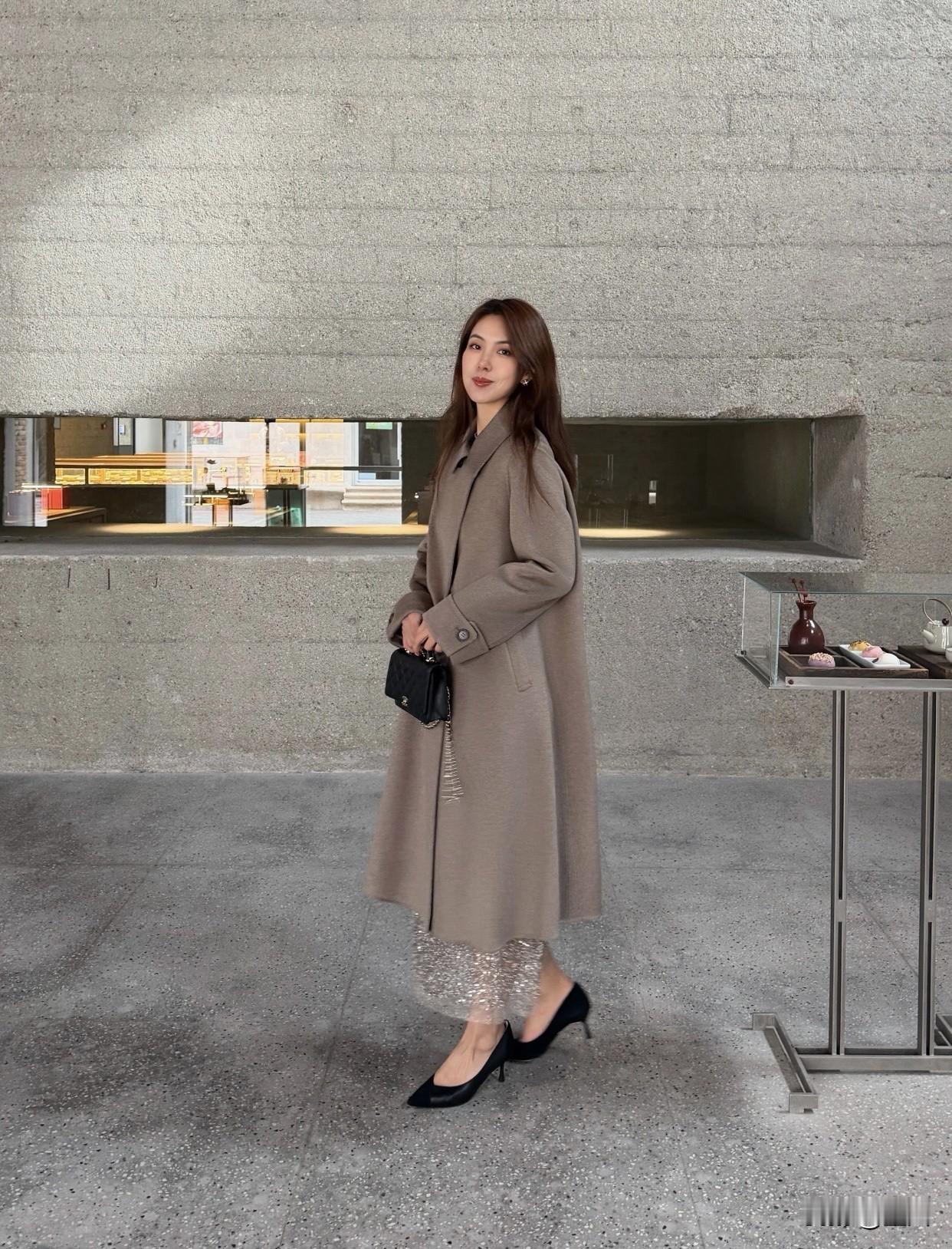 什么样的穿搭可以成为气质女神?翻领妮子大衣内搭网纱裙手拿黑色包包这搭配就很绝。秋