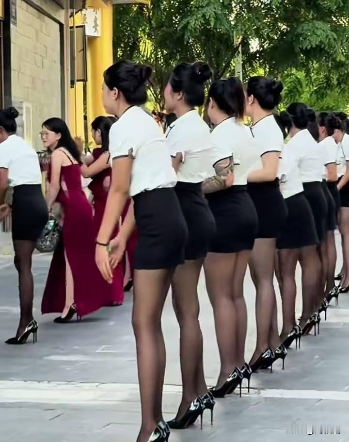 整齐统一的制服、精致的妆容，一众女子肤白貌美、修长的大长腿格外显眼，列队等候接待