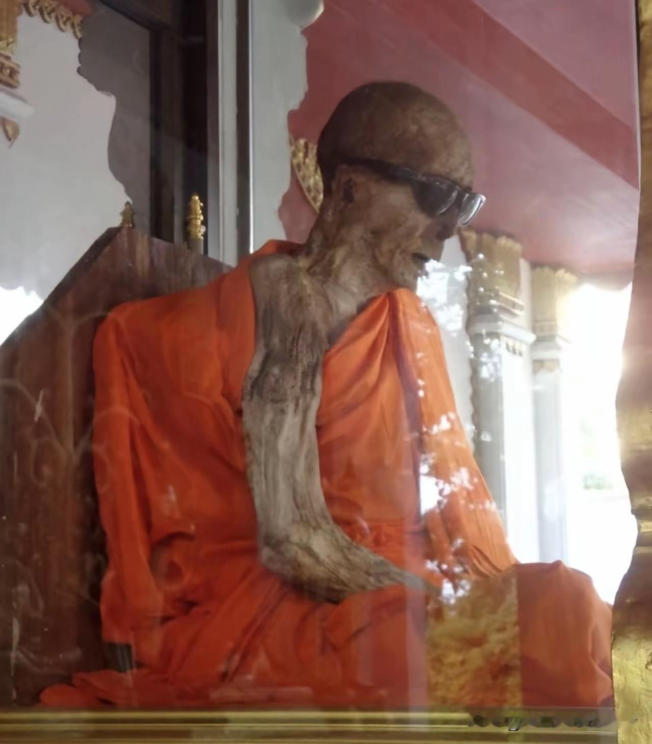 泰国有座寺庙叫坤那拉姆寺。玻璃棺材里坐着一个和尚，戴着黑墨镜。很多人第一