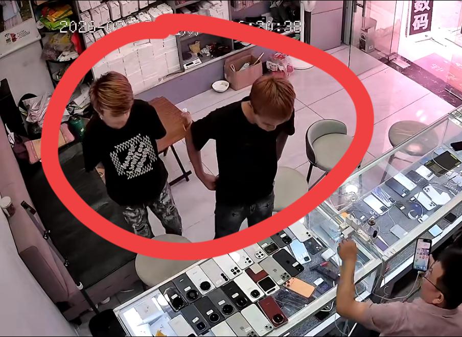 两个染黄毛的精神小伙走进一家手机店，装作想购买手机，趁老板不备拿起手机就跑了。事