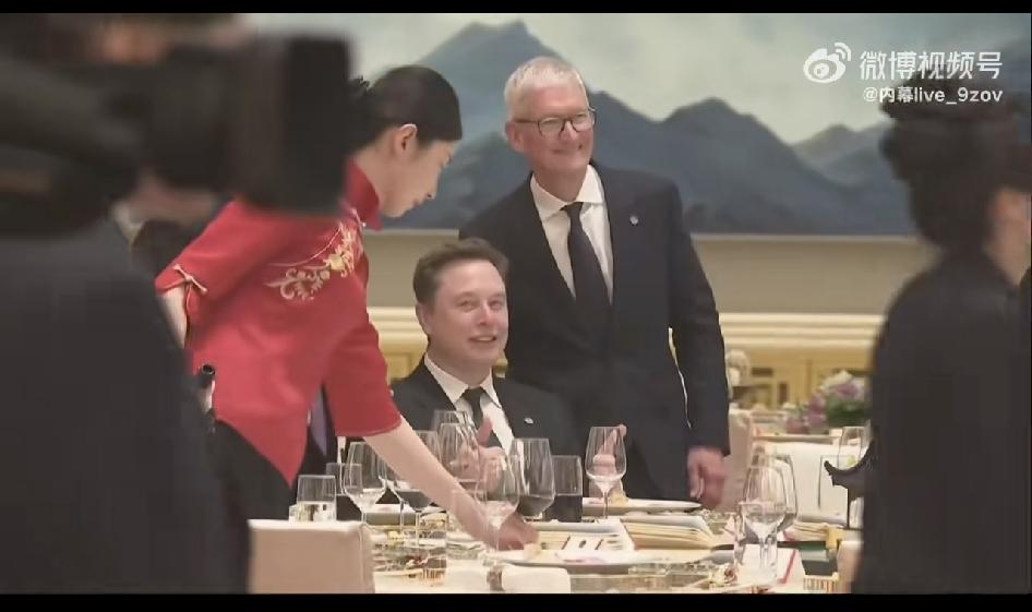 欢迎会晚宴上，马斯克与苹果的库克合影留念。注意看，老马看服务员时那小眼神。