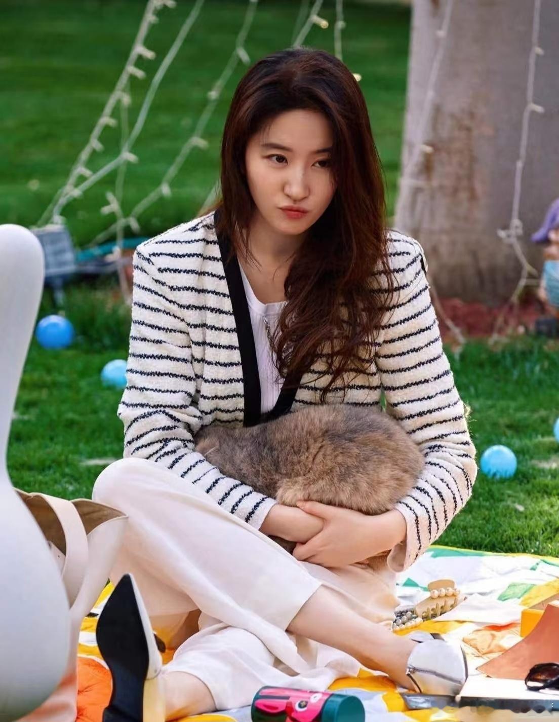 刘亦菲的穿搭无疑成为了焦点。她身着一件黑白条纹小香风针织开衫，经典的条纹元素搭配