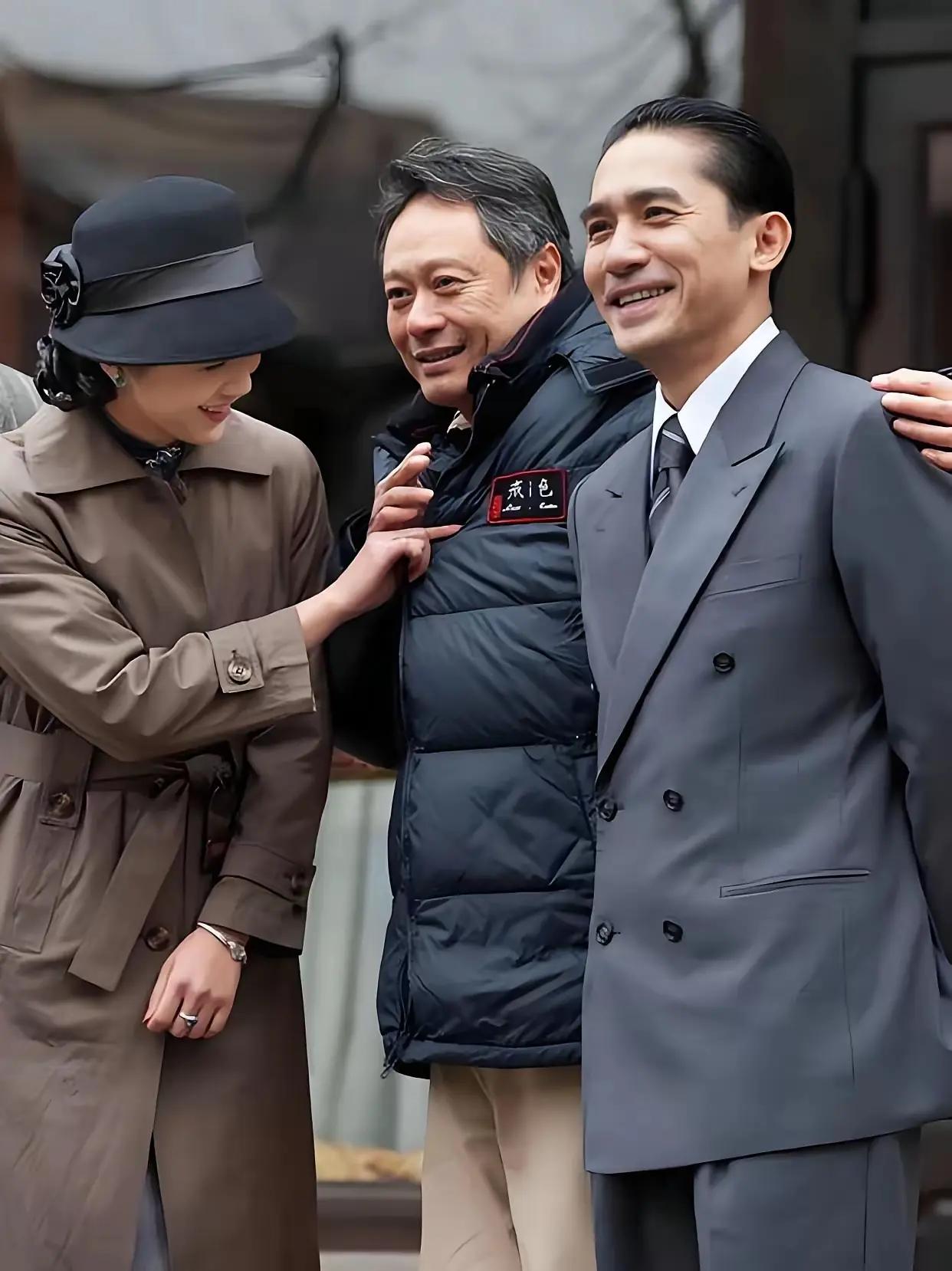 《色戒》导演李安，与男主梁朝伟和女主汤唯。巧合的是，李安的羽绒服上还印着《色戒》