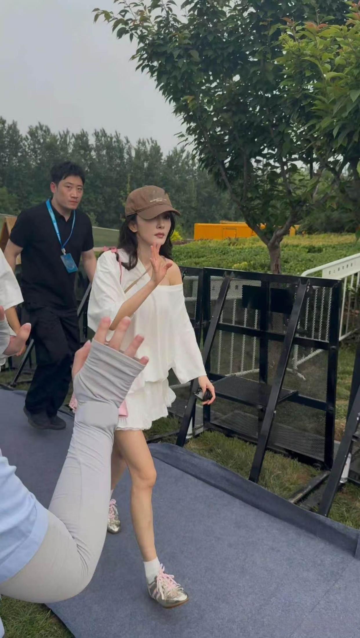 路人镜头中的杨幂，这次的穿搭很休闲呀！宽松露肩白色T恤搭配荷叶边短半身裙，温柔
