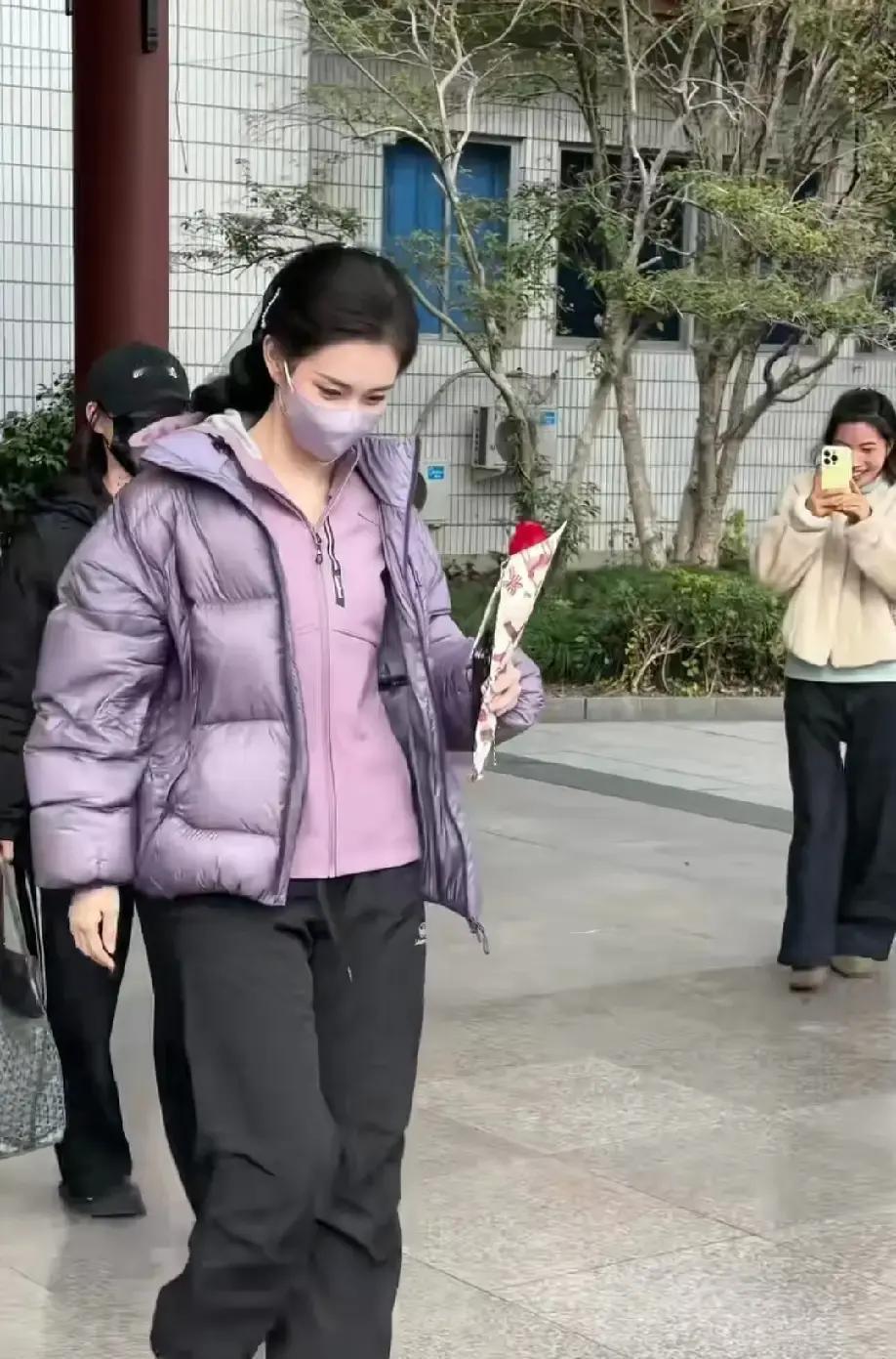 别信什么“大红大紫”的玄学。横店这位穿紫衣拿玫瑰的千金，靠的不是道具，是一套被