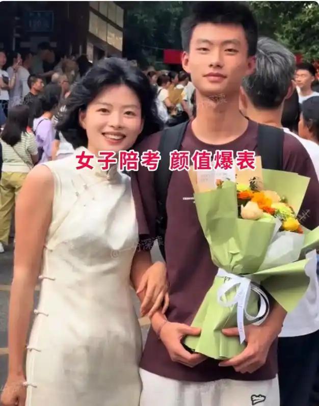 高考考场外这一幕，一眼就让人挪不开目光。妈妈一身素雅米白色无袖旗袍，温婉灵动，一