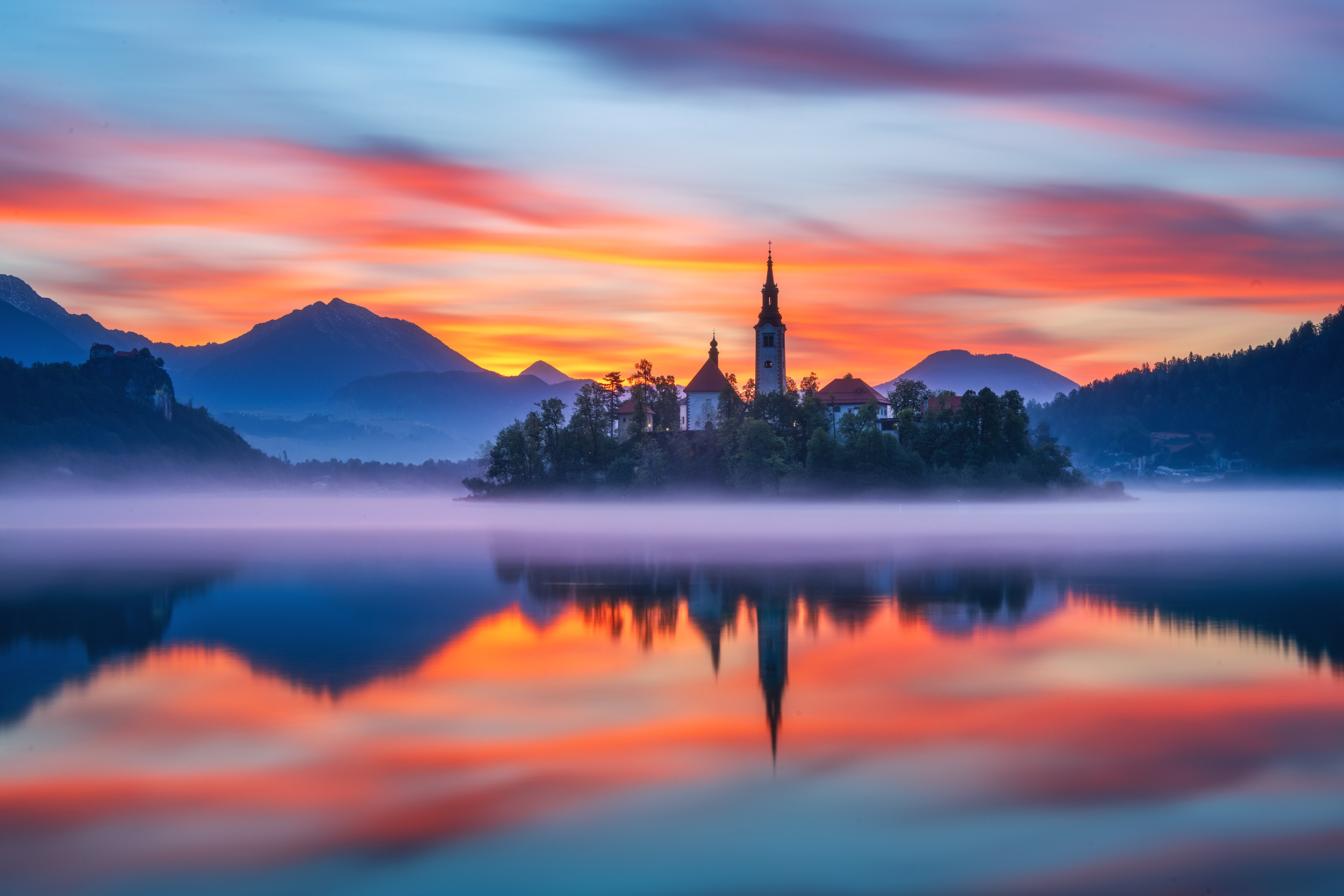 阿尔卑斯脚下的蓝宝石——布莱德湖。湖心岛教堂尖顶刺破晨雾，古堡对望雪峰，湖面