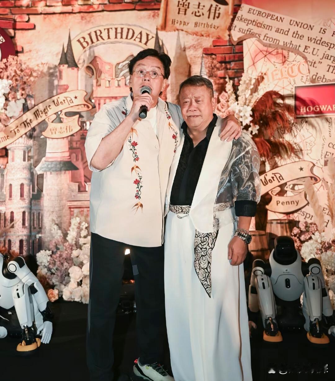 曾志伟在深圳一家五星级酒店庆祝73岁生日，他穿着一身名牌衣服，笑容满面，和一位男