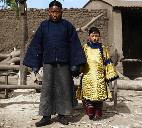 这张晚清的照片里，裹着厚实深色棉褂的丈夫立在院场中，宽宽的衣摆衬得身形愈发高大壮