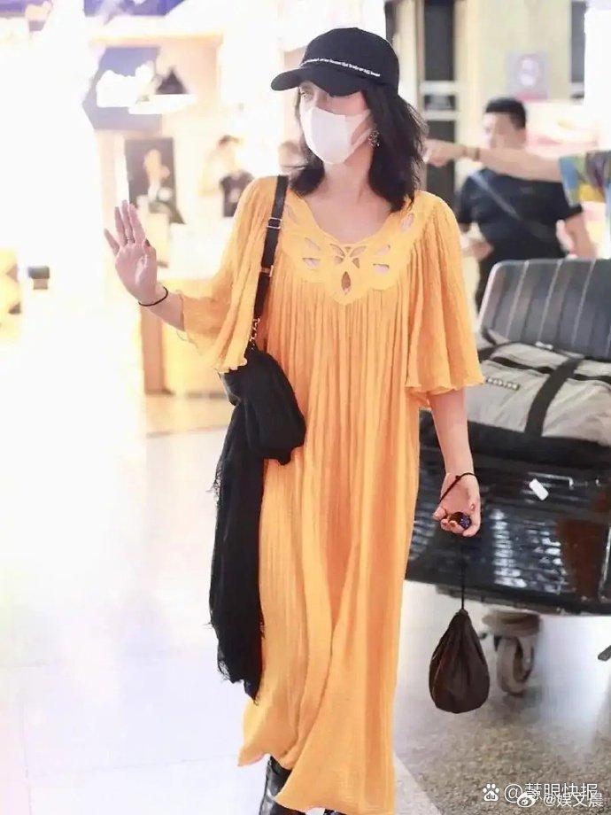 周迅机场穿搭随性自在，一身黄色长款宽松连衣裙，满满慵懒氛围感。
