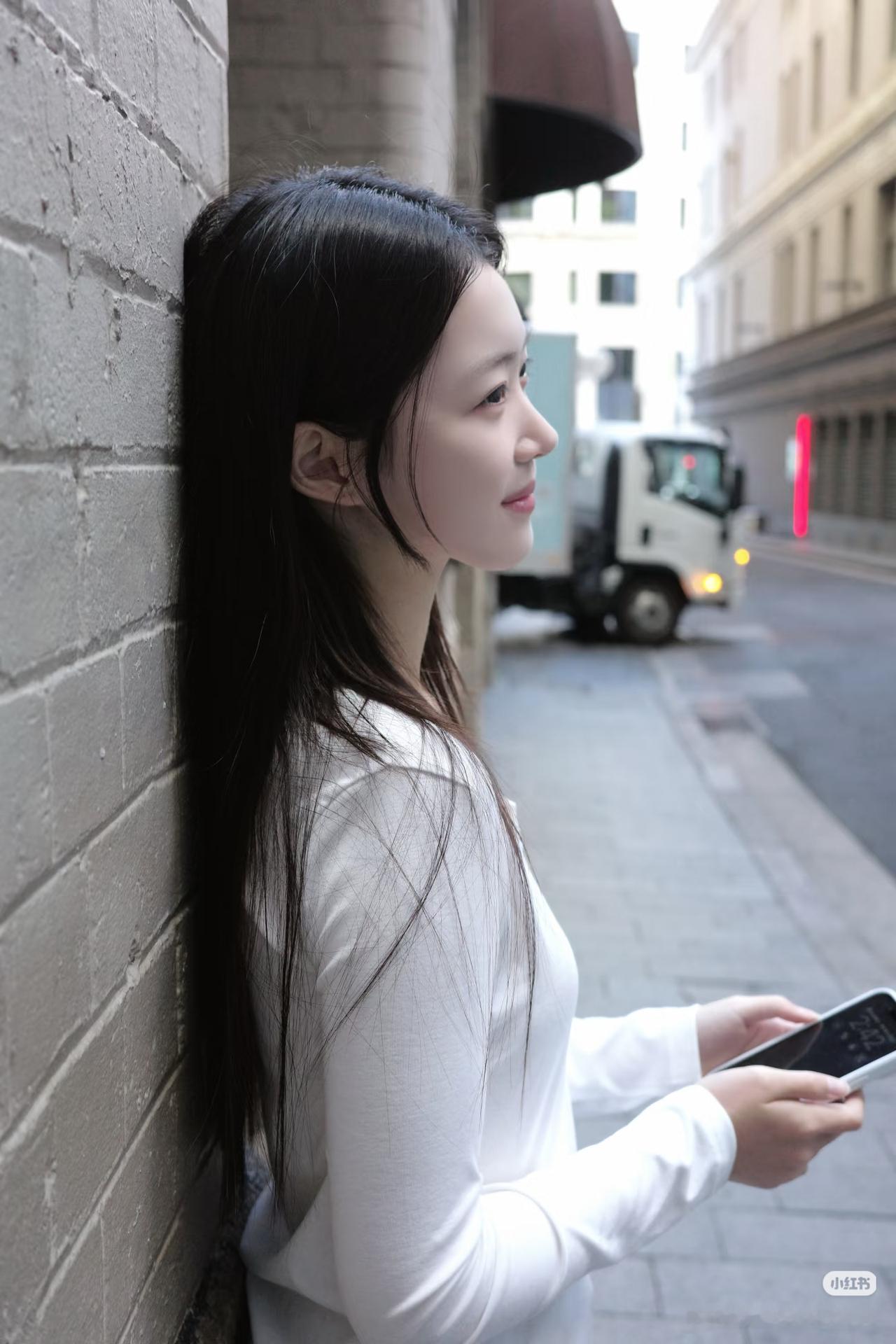 都市少女靠墙静思，手机相伴，静谧时光