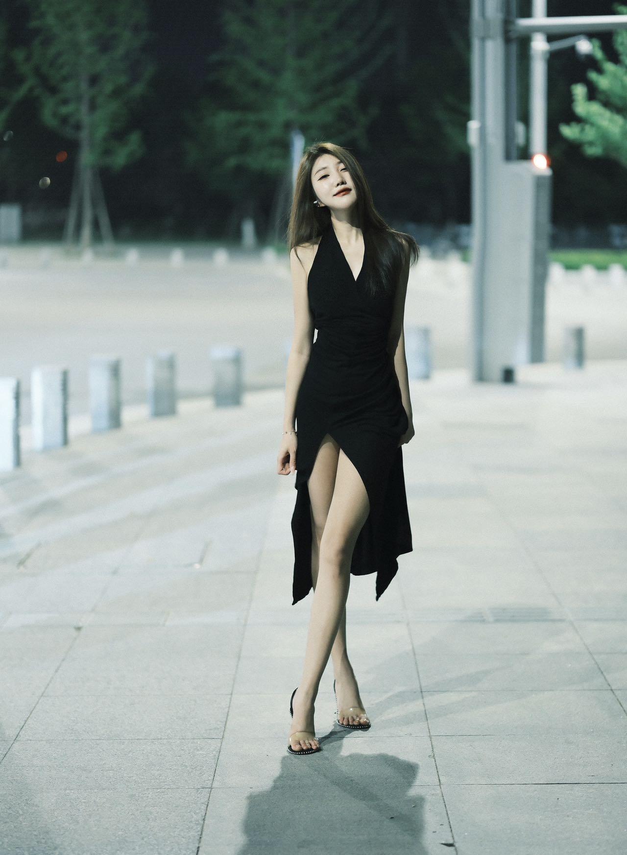 夜晚漫步，黑裙飘逸，自信步伐，都市风范。